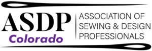 A mostly black and white logo with a pair of sewing needles above and below.  The letters A S D P are on the left and the words Association of Sewing and Design Professionals is on the right.  The word Colorado in purple is written under the letters A S D P.